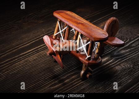 Holz Spielzeugflugzeug handgefertigtes Modell auf rustikalem Holztisch. Stockfoto