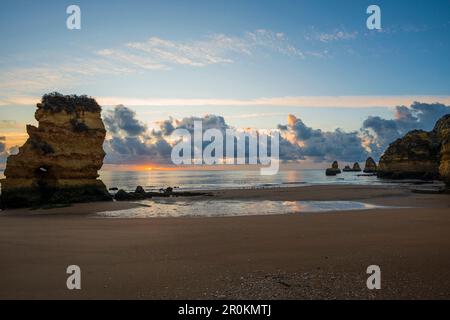 Farbige Felsen und Sonnenaufgang am Strand, Praia da Dona Ana, Lagos, Algarve, Portugal Stockfoto