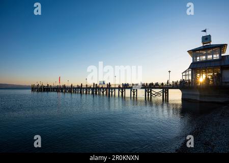 Menschen auf der Anlegestelle bei Sonnenuntergang, Schiffsanlegestelle, Kressbronn, Bodensee, Baden-Württemberg, Deutschland Stockfoto