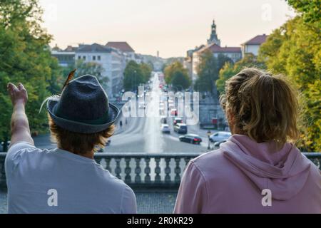 Zwei junge Männer stehen an der Friedensengel und blicken über die Luitpold-Brücke, München, Oberbayern, Deutschland Stockfoto