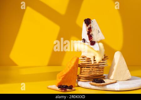 Set oder Sortiment mit Käse und Crackern. Rotes Stilton, Cambozola, Brie, Cheddar, hausgemachte rote Johannisbeermarmelade und Cracker auf weißem Marmorbrett und Schrei Stockfoto