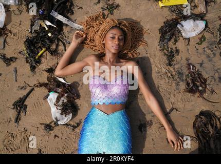 REDAKTIONELLE VERWENDUNG NUR Chisanga Mwila, gekleidet als Ariel von der kleinen Meerjungfrau am Cullercoats Beach, Newcastle, vor dem Live-Remake des Films 2023 als Teil einer Sensibilisierungskampagne des nachhaltigen Toilettenpapierunternehmens Oceans, die die negativen Auswirkungen der Meeresverschmutzung an der britischen Küste hervorhebt. Ausgabedatum: Dienstag, 9. Mai 2023. Stockfoto