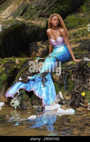 REDAKTIONELLE VERWENDUNG NUR Chisanga Mwila, gekleidet als Ariel von der kleinen Meerjungfrau am Cullercoats Beach, Newcastle, vor dem Live-Remake des Films 2023 als Teil einer Sensibilisierungskampagne des nachhaltigen Toilettenpapierunternehmens Oceans, die die negativen Auswirkungen der Meeresverschmutzung an der britischen Küste hervorhebt. Ausgabedatum: Dienstag, 9. Mai 2023. Stockfoto