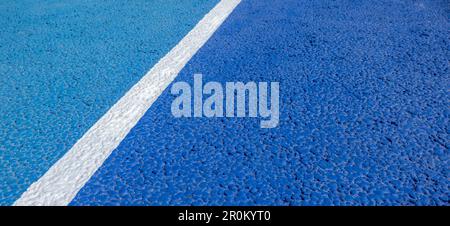 Hintergrund des Sportplatzes. Blaue gummierte und granulierte Oberfläche mit weißen Linien auf dem Boden. Draufsicht Stockfoto