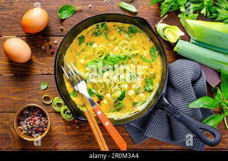 Omelette mit Lauch und Kräutern, köstlicher Snack oder Frühstück auf Holzhintergrund Stockfoto