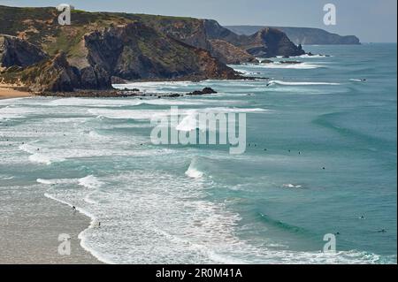 Steile Küste und Surfer am Strand Praia de Amado in der Nähe von Carrapateira, Parque Natural do Sudoeste Alentejano e Costa Vicentina, Atlantik, Distrikt F Stockfoto