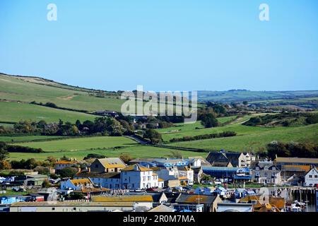 Erhöhte Aussicht über die Dächer der Stadt in Richtung Landschaft vom South West Coast Path, West Bay, Dorset, Großbritannien. Stockfoto