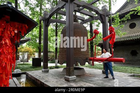 (230509) -- XI'AN, 9. Mai 2023 (Xinhua) -- Ein Tourist läutet die Glocke am Jianfu Tempel in Xi'an, Nordwestchina Provinz Shaanxi, 8. Mai 2023. XI'an, eine Stadt mit über 3.100 Jahren Geschichte, diente als Hauptstadt für 13 Dynastien in der chinesischen Geschichte. Es ist auch die Heimat der weltberühmten Terrakotta-Krieger, die in der Qin-Dynastie (221-207 v. Chr.) geschaffen wurden. Die kleine Wildgans-Pagode befindet sich im Jianfu-Tempel und wurde während der Herrschaft des Kaisers Zhongzong der Tang-Dynastie (618-907) in der Jinglong-Zeit (701-710) erbaut, um die buddhistischen Sutras von Mönch Yi Jing zu speichern. (Xinhua/Liu Xiao) Stockfoto