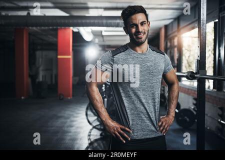 Schlechte Tage können besser werden, wenn man ins Fitnessstudio geht. Porträt eines gutaussehenden jungen Mannes im Fitnessstudio für ein Workout. Stockfoto