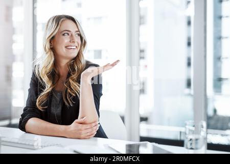 Noch nie sah der Kopierbereich professioneller aus. Eine junge Geschäftsfrau, die in einem modernen Büro mit ihrer Hand an ihrem Schreibtisch Gesten macht. Stockfoto