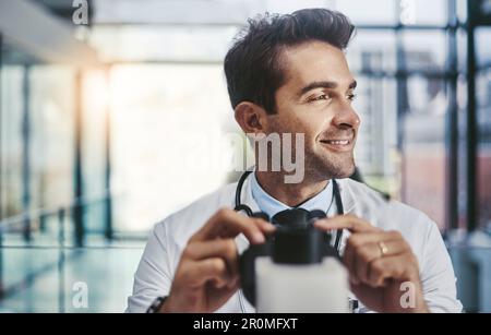 Das könnte die Lösung sein. Ein junger, gutaussehender Wissenschaftler, der in einem Labor mit einem Mikroskop arbeitet. Stockfoto