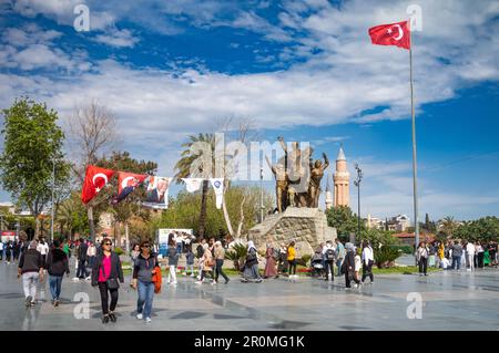 Menschen machen einen Spaziergang auf dem Platz der Republik neben der Statue des Nationalhelden Mustafa Kemal Atatürk auf einem Pferd in Antalya, Türkei (Turkiye). Im Abstand m Stockfoto