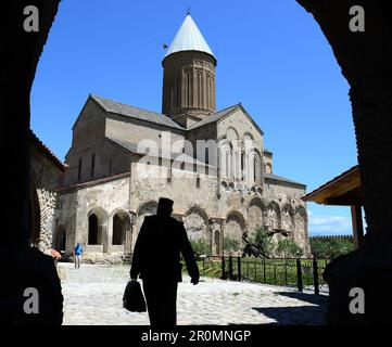 Mönch mit Aktentasche kommt im Innenhof des Klosters Alaverdi, Kakheti, Ostgeorgien an Stockfoto