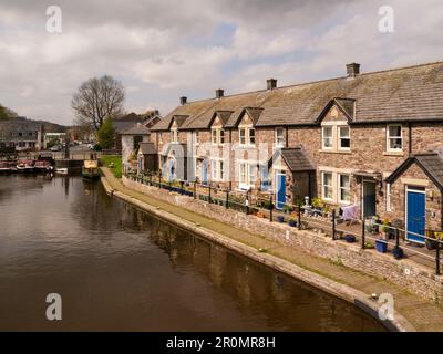 Attraktive Reihe von Häusern an der Seite der Brecon Basin Canal Wharf mit direktem Zugang nach Monmouthshire und Brecon Canal, Powys Mid Wales UK Stockfoto