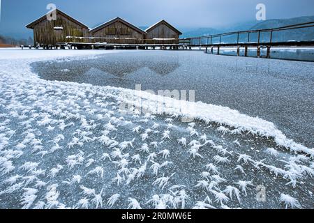Eisblumen auf dem gefelteenen Kochelsee mit Blick auf die drei Holzhütten und den Anleger, im Hintergrund Nebel, Winter, Schlehdorf, Alpenvorland Stockfoto
