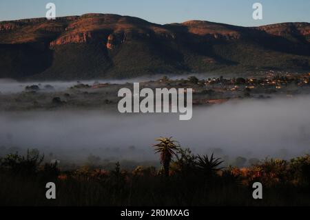 An einem kühlen frühen Wintermorgen schwebt eine Nebeldecke über dem Dorf GA-Maja in der südafrikanischen Provinz Limpopo Stockfoto