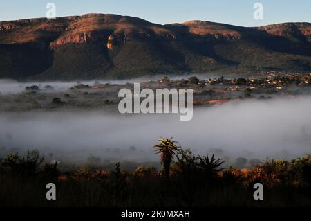 An einem kühlen frühen Wintermorgen schwebt eine Nebeldecke über dem Dorf GA-Maja in der südafrikanischen Provinz Limpopo Stockfoto