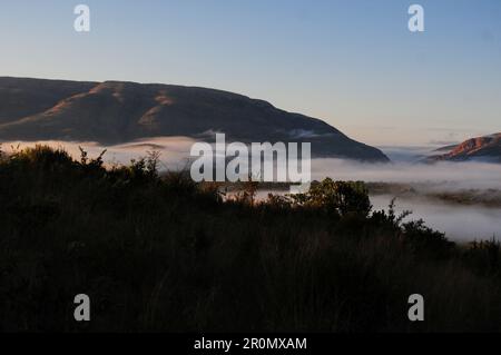An einem kühlen frühen Wintermorgen schwebt eine Nebeldecke über dem Dorf GA-Maja in der südafrikanischen Provinz Limpopo Stockfoto