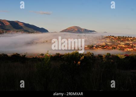 An einem kühlen frühen Wintermorgen schwebt eine Nebeldecke über dem Dorf GA-Maja in der südafrikanischen Provinz Limpopo Stockfoto