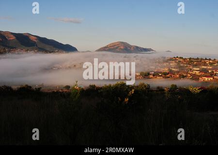 An einem kühlen frühen Wintermorgen schwebt eine Nebeldecke über dem Dorf GA-Maja in der südafrikanischen Provinz Limpopo Stockfoto