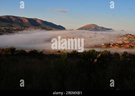 An einem kühlen frühen Wintermorgen schwebt eine Nebeldecke über dem Dorf GA-Maja in der südafrikanischen Provinz Limpopo Stockfoto
