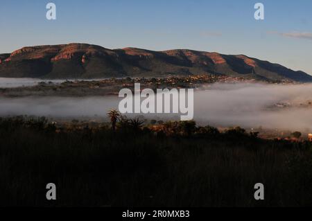 An einem kühlen frühen Wintermorgen schwebt eine Nebeldecke über dem Dorf GA-Maja in der südafrikanischen Provinz Limpopo Stockfoto
