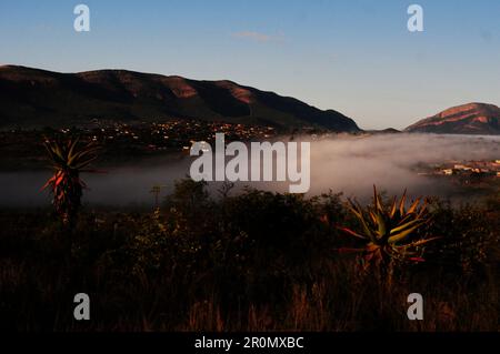 An einem kühlen frühen Wintermorgen schwebt eine Nebeldecke über dem Dorf GA-Maja in der südafrikanischen Provinz Limpopo Stockfoto