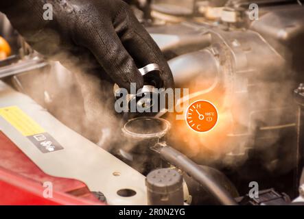 Der automatische Mechaniker öffnet die Kühlerverschlusskappe, wobei Dampf aus dem Symbol für hohe Temperatur und Wassertemperatur mit hoher temperatur aus dem Motorraum entweicht Stockfoto