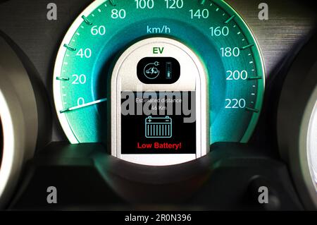 Warnleuchte für niedrigen Batteriestand auf schwarzem Bildschirm auf der Instrumententafel des Elektrofahrzeugs, Konzept der Elektrofahrzeugtechnologie. Stockfoto