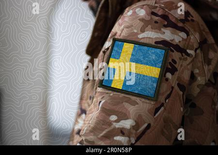 Schweden Soldat. Soldat mit schwedischer Flagge, schwedischer Flagge auf Militäruniform. Tarnkleidung Stockfoto