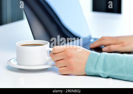 Nahaufnahme einer Frau Hände arbeiten mit einem Laptop in einem Café-Tisch Stockfoto