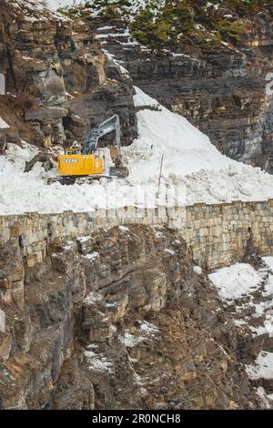 West Glacier, Vereinigte Staaten von Amerika. 24. April 2023. Schneepflug-Crews verwenden schwere Ausrüstung, um auf der Going-to-the-Sun Road während des jährlichen Rodungsvorgangs im Glacier-Nationalpark am 24. April 2023 in West Glacier, Montana, durch tiefe Schneewehen zu pflügen. Die gefährliche Arbeit dauert zehn Wochen, um Schneewehen bis zu 80 Fuß tief im Frühjahr zu entfernen, bevor die Straße wieder geöffnet werden kann. Kredit: Daniel Lombardi/National Park Service/Alamy Live News Stockfoto