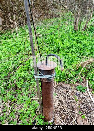 Wasserhahn von Brunnenrohren im Hinterhof des Dorfes am Frühlingstag Stockfoto