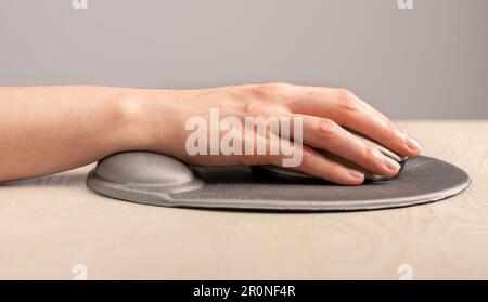 Hand-auf-Computer-Maus auf Polster mit Handgelenkauflage, Stütze. Stockfoto