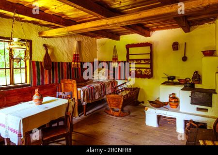 Sibiu, Rumänien - 25. Juli 2021. Traditionelle rumänische Volkshaus Interieur mit ländlichen Möbeln und Dekoration. Stockfoto