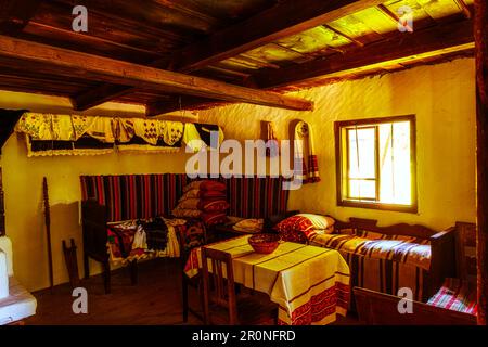 Sibiu, Rumänien - 25. Juli 2021. Traditionelle rumänische Volkshaus Interieur mit ländlichen Möbeln und Dekoration. Stockfoto