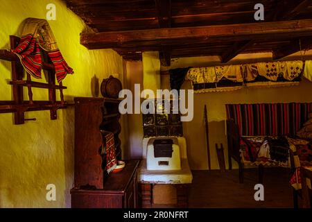 Sibiu, Rumänien - 25. Juli 2021. Traditionelle rumänische Volkshaus Interieur mit ländlichen Möbeln und Dekoration. Stockfoto