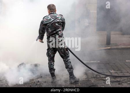 Beirut, Beirut, Libanon. 9. Mai 2023. Ein Feuerwehrmann löscht brennende Reifen auf einer Straße nach einem Protest von Bankeinlegern in der Nähe des Parlaments in Beirut, Libanon am 9. Mai 2023. Die Brände wurden von Bankeinlegern angezündet, die seit 2019, als die Wirtschaft zusammenbrach, gegen illegale Beschränkungen protestierten, die von lokalen Banken für Abhebungen und Überweisungen verhängt wurden. (Kreditbild: © Daniel Carde/ZUMA Press Wire) NUR REDAKTIONELLE VERWENDUNG! Nicht für den kommerziellen GEBRAUCH! Kredit: ZUMA Press, Inc./Alamy Live News Stockfoto