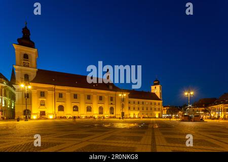 Piata Mare mit römisch-katholischer Pfarrkirche und Rathausturm bei Sonnenuntergang, Sibiu, Siebenbürgen, Rumänien Stockfoto