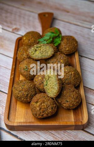 Falafel-Kugeln auf einem Holzbrett und Tahini-Sauce Stockfoto