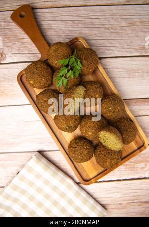 Falafel-Kugeln auf einem Holzbrett und Tahini-Sauce Stockfoto