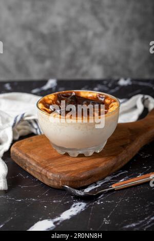 Milchreis auf dunklem Hintergrund. Reispudding Dessert mit Milch. Türkische Köstlichkeiten Stockfoto