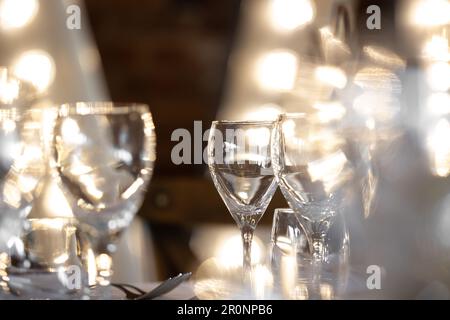 Wunderschöne Gläser für Toasts, die mit Hintergrundbeleuchtung für die Hochzeitsfrühstückszeremonie serviert werden Stockfoto