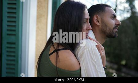 Freundin umarmte Freund von hinten, während sie draußen auf dem Balkon stand. Ein liebenswertes Paar aus dem Nahen Osten, das Liebe und Unterstützung zeigt, während conte Stockfoto