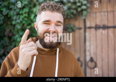 Ein hübscher, lockiger Mann nimmt ein Video von sich auf - Video-Blog und Jugend-Blogger-Konzept Stockfoto