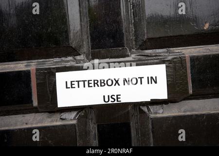 Das Schild Briefkasten nicht in Gebrauch klebt über Briefkasten in einer schwarzen Tür Stockfoto