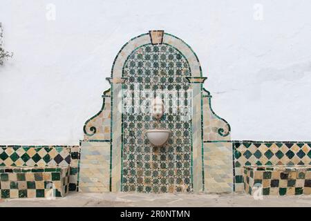 Nahaufnahme des Wasserbrunnens mit Fliesen an der weißen Wand im Innenhof des mittelalterlichen königlichen Nationalpalastes Sintra oder des Stadtpalastes in Sintra Stockfoto