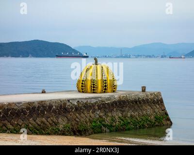 Gelbe Kürbisskulptur des japanischen Künstlers Yayoi Kusama auf der Insel Naoshima, Japan. Die Insel beherbergt eine Sammlung zeitgenössischer Kunst, die m ist Stockfoto