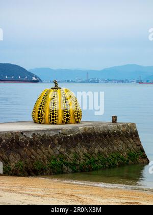 Gelbe Kürbisskulptur des japanischen Künstlers Yayoi Kusama auf der Insel Naoshima, Japan. Die Insel beherbergt eine Sammlung zeitgenössischer Kunst, die m ist Stockfoto