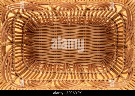 Ein Korb aus Weinreben auf einem Holztisch, Nahaufnahme, Draufsicht. Stockfoto